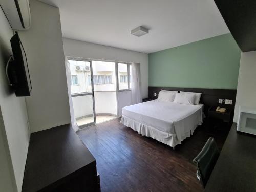 贝洛奥里藏特Wafeh Flats em San Diego Pampulha的卧室配有白色的床和电视。
