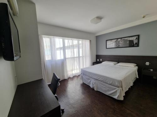 贝洛奥里藏特Hotel San Diego Pampulha - Flats Particular的一间卧室设有一张床和一个大窗户