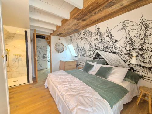 安格勒A l'orée des bois的卧室配有一张挂有山壁画的床。