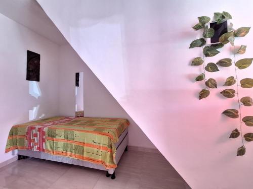 萨尔瓦多Mar.5: Compact close to Stella Maris beach and Airport的卧室配有一张挂在墙上的植物床