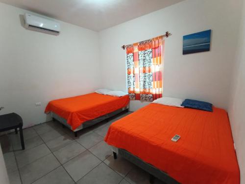 蒙特里科CASA PARLAMAR的客房设有两张床、一张桌子和一个窗户。