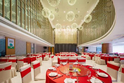 福州福建阳光假日大酒店的一个带红色桌子和白色椅子的大型宴会厅