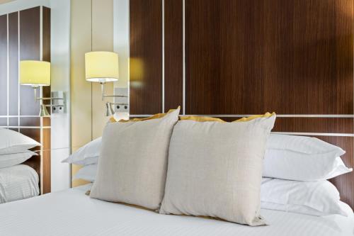 黄金海岸Cosy Studio with Ocean Views & Rooftop Jacuzzis的一张带白色枕头和木制床头板的床