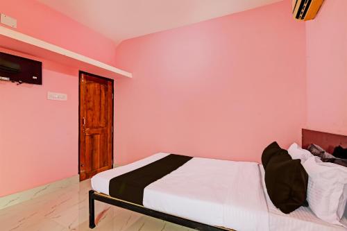 克塔克OYO MAA BHUASUNI RESIDENCY的卧室配有一张粉红色墙壁上的床铺