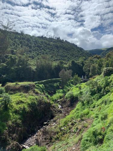 基多Hacienda la campiña的享有山丘和田野河流的景色