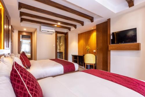 加德满都Kailash Boutique Hotel的酒店客房设有两张床和电视。