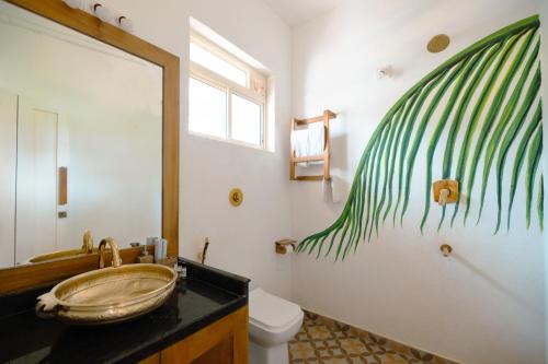 PadubidriNilaya Stays的一间带水槽的浴室和一个带壁画的卫生间。