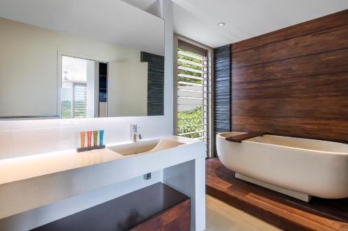 维拉港陶乐苑精品公寓的带浴缸、水槽和镜子的浴室