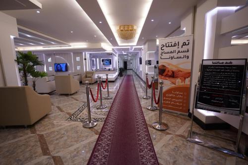泰布克Hotel and Apartments Al Raqi Mall Artiaad的一间位于大楼中间的铺有红地毯的房间