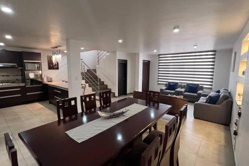 伊瓦拉Home Ibarra Parque Ciudad Blanca的用餐室以及带桌椅的起居室。
