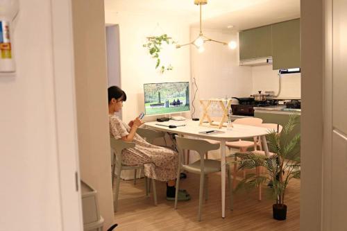 首尔3rooms 4beds kitchen Hongik Stn 3min的坐在电脑前桌边的女人