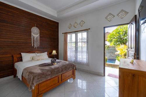 蓝梦岛Widia Homestay Nusa Lembongan的一间卧室设有一张床和一个大窗户