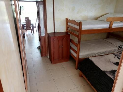 La SerenaAPARTAMENTO CAMPESTRE CHINAUTA的客房设有两张双层床和一张桌子。