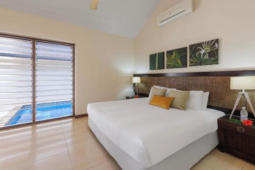 维拉港芒果度假酒店的卧室设有一张白色大床和一扇窗户。