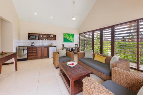 维拉港芒果度假酒店的带沙发和桌子的客厅以及厨房。