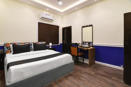 加尔各答OYO Hotel sakina的一间卧室配有一张床、一张书桌和一面镜子