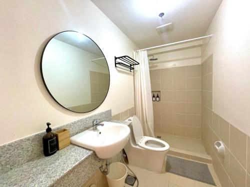马尼拉mushROOM Condotel at Infina Towers, Quezon City的一间带水槽、卫生间和镜子的浴室