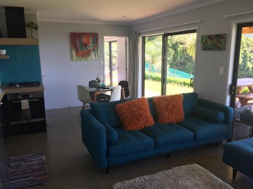 卡蒂卡蒂Kaimai Range Country Getaway的客厅配有蓝色的沙发和桌子