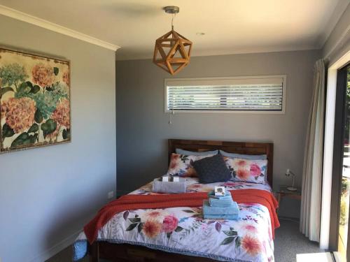 卡蒂卡蒂Kaimai Range Country Getaway的一间卧室配有一张带红色毯子的床