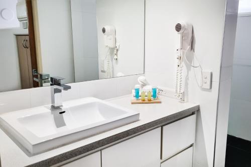 黄金海岸Tiki Hotel Apartments Surfers Paradise的白色的浴室设有水槽和镜子