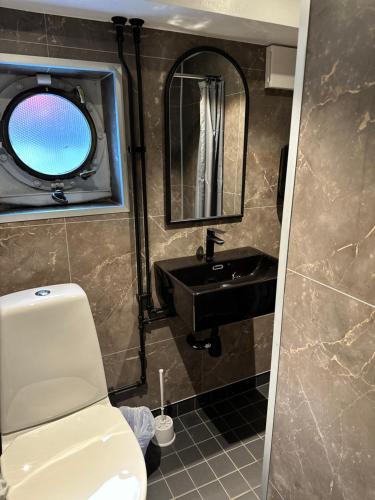 斯德哥尔摩丹罗达巴腾酒店的一间带卫生间、水槽和镜子的浴室
