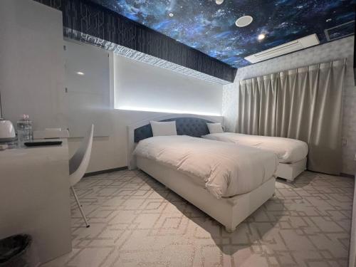 东京Hotaku HOTEL Akihabara的星空天花板的客房内的两张床