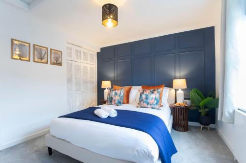 切尔滕纳姆Beautiful Victoria Retreat的一间卧室配有一张大床和蓝色床头板