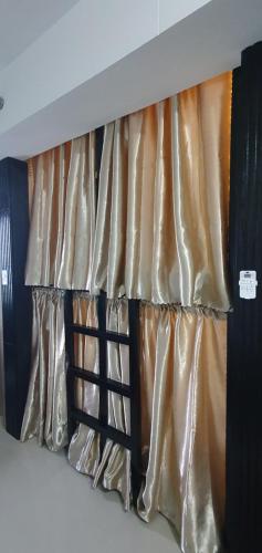 马尼拉C Place - Capsule B的一张带金色和黑色窗帘的床