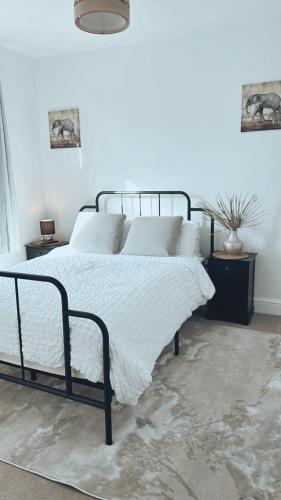 朴次茅斯Southsea HomeStays - Three Bedroom Home, Sleeps 8 - with Garden & Hot Tub的一间卧室配有一张带白色毯子的床