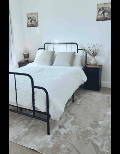 朴次茅斯Southsea HomeStays - Three Bedroom Home, Sleeps 8 - with Garden & Hot Tub的一间卧室配有带白色床单和枕头的床。