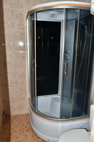 Korumdyпансионат Нептун的一间带卫生间的浴室内的玻璃淋浴间