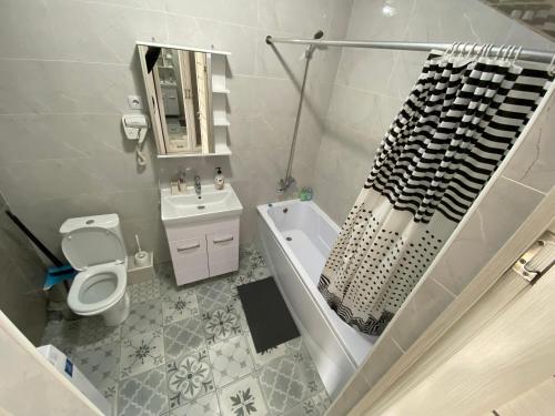 阿斯塔纳Astana Arena Apartment的浴室配有盥洗盆、卫生间和浴缸。