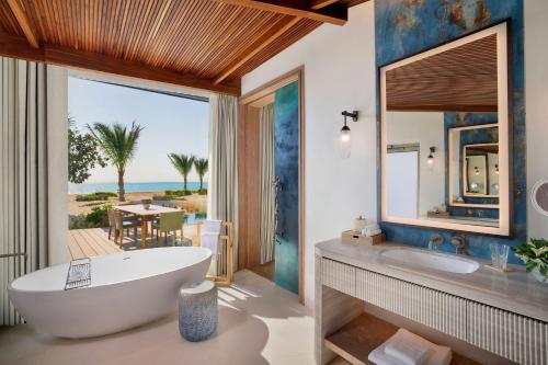 ḨanakThe St. Regis Red Sea Resort的带浴缸的浴室,享有海景。