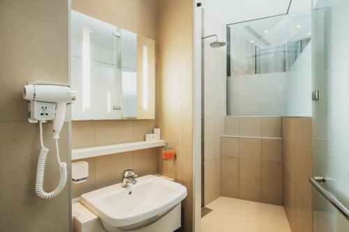 Moka瓦拉巴嘎迢勒酒店的一间带水槽和淋浴的小浴室