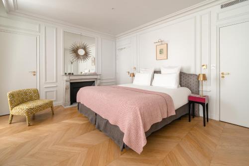 巴黎Hôtel Bourgogne & Montana的一间卧室配有一张大床和一把椅子