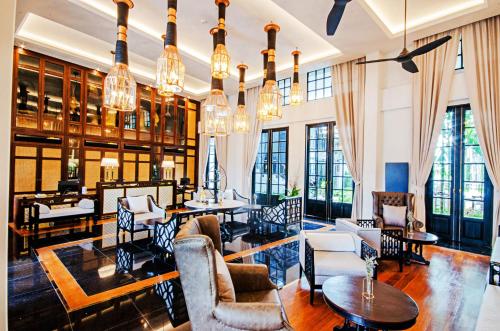 清迈Buri Sriping Riverside Resort & Spa - SHA Extra Plus的客厅配有许多家具和窗户。