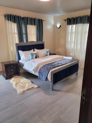 内罗毕Gloria House的一间卧室配有一张大床和地毯。