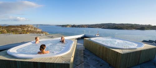 Steinsland全景酒店及度假村的两个女孩坐在甲板上的热水浴缸里