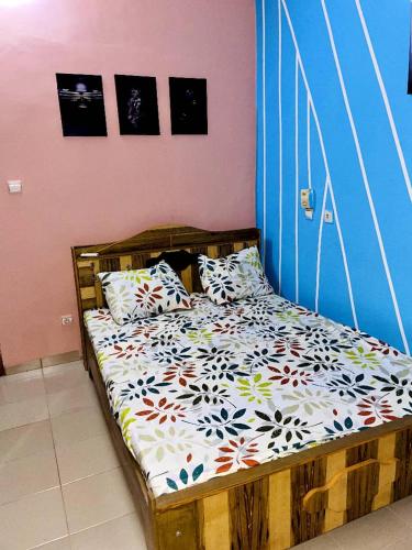 瓦加杜古Burkina meublé的一间卧室配有一张带枕头的木床