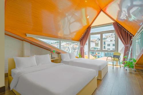 大叻Nắng Chiều Central Hotel的一间卧室设有两张床和大窗户