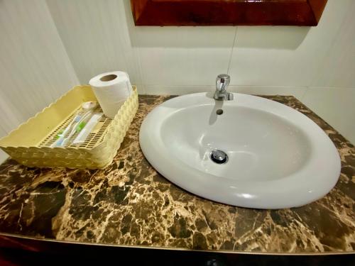 暹粒金木瓜宾馆的浴室水槽,在台面上摆放着一卷卫生纸