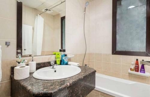 迪拜Manzil - Studio Apartment in Dubai Silicon Oasis near Dubai Outlet Mall的浴室配有盥洗盆和浴缸。