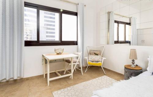 迪拜Manzil - Studio Apartment in Dubai Silicon Oasis near Dubai Outlet Mall的白色卧室配有桌子和椅子