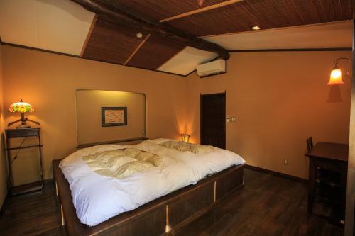 箱根纪伊国屋旅馆的一间卧室配有一张带白色床单的大床
