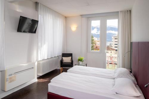 洛迦诺Hotel Rio Muralto的卧室配有白色的床和窗户。