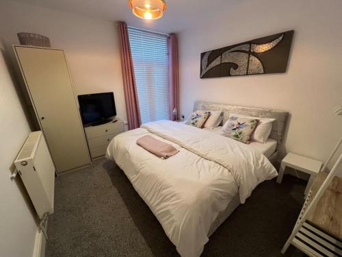 滨海圣安娜New Flat in Lytham St Annes - Sleeps 4的一间卧室配有一张大床和电视