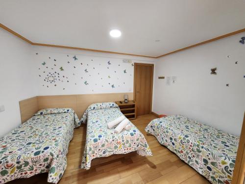 贝洛拉多Caminante的卧室配有两张床,墙上挂着蝴蝶。