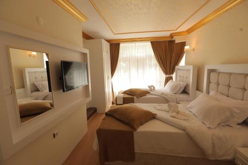 阿马西亚GARDEN OTEL AMASYA的酒店客房,设有两张床和镜子