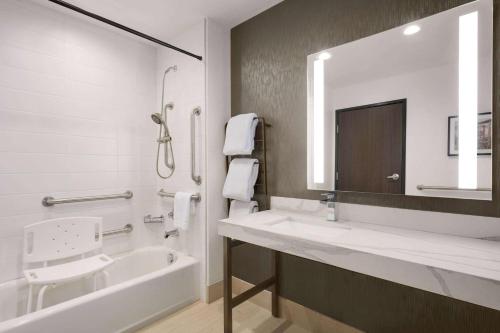 帕克La Quinta Inn & Suites by Wyndham Denver Parker的一间带水槽、浴缸和镜子的浴室