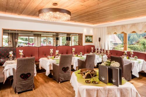 塞尔瓦迪加尔代纳山谷朵夫山魅力酒店的一间带桌椅和吊灯的餐厅